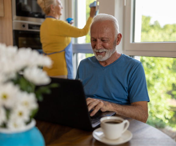 Older couple in their kitchen looking at laptop