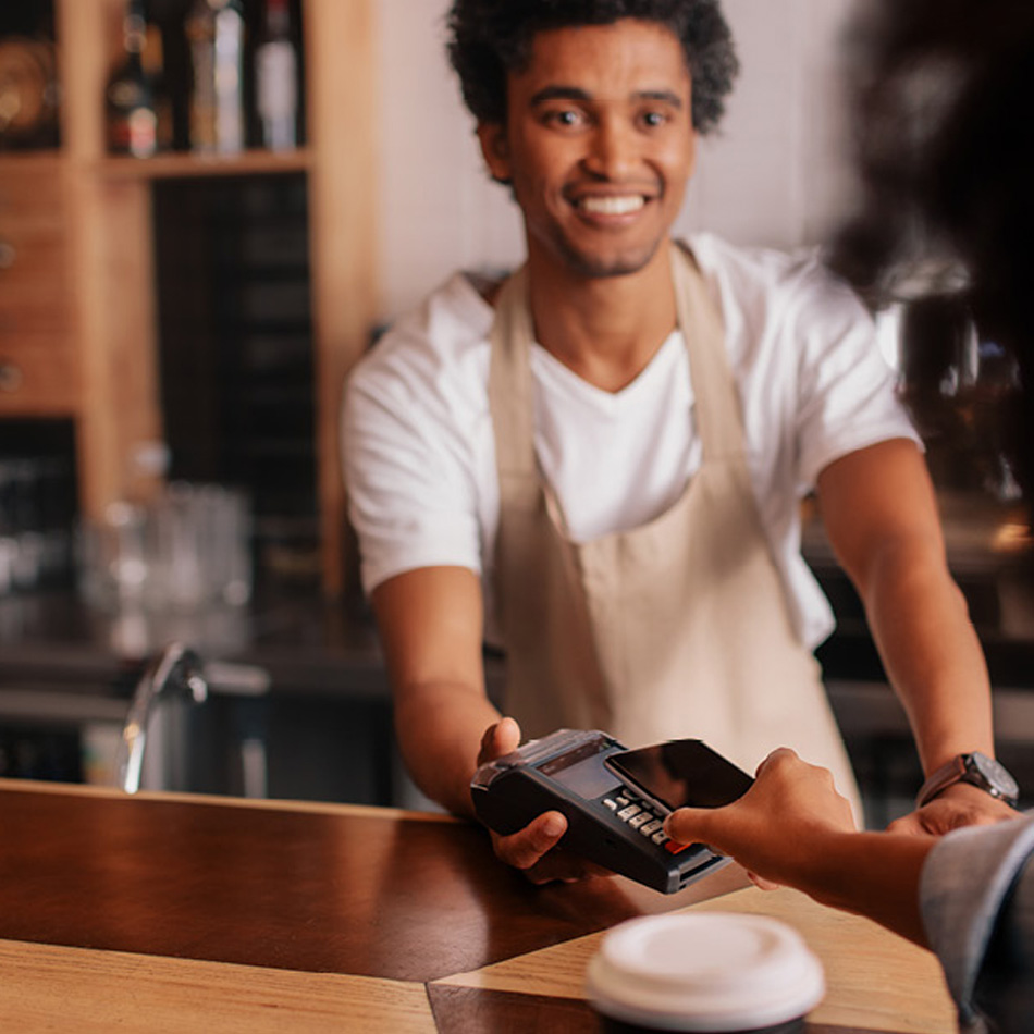 Young barista taking a credit card payment