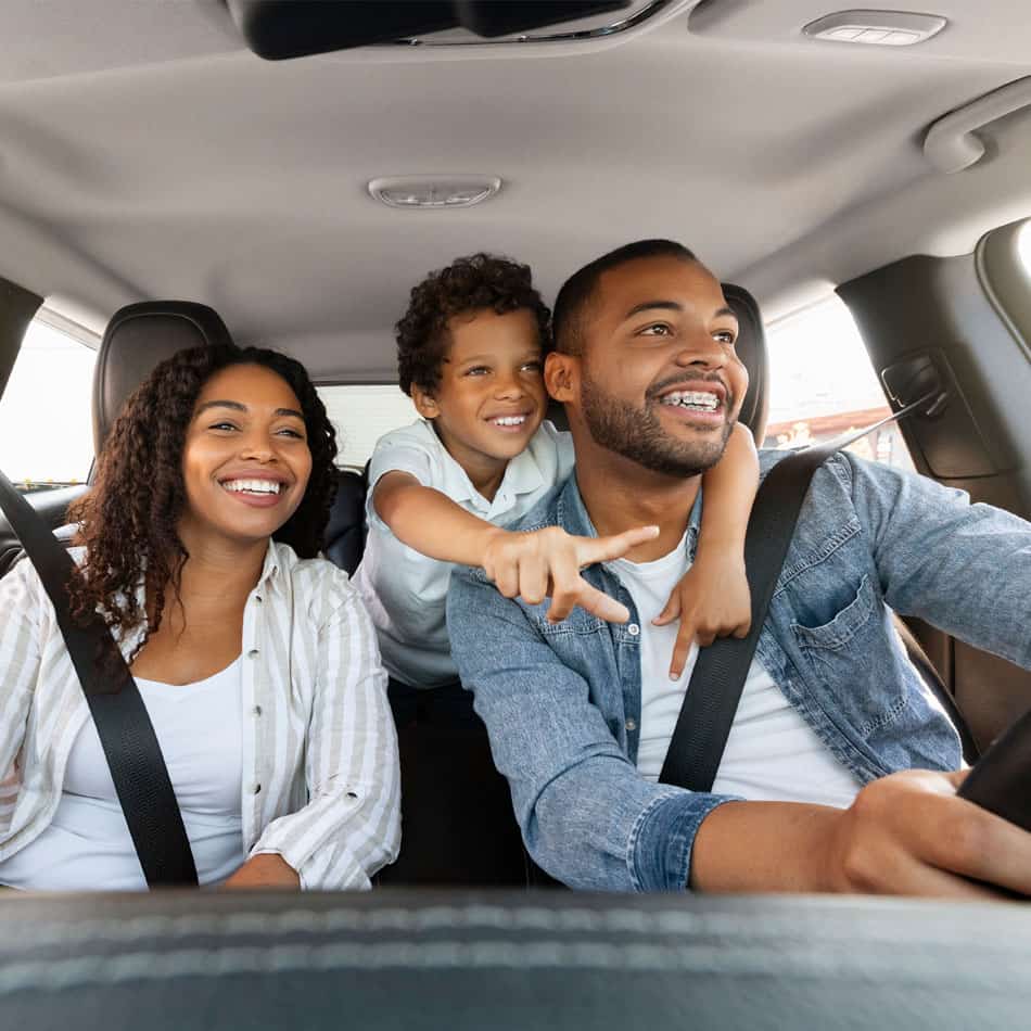 Couple in new car with young boy.